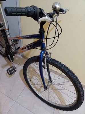 Manillar de la rueda delantera y cesta de una bicicleta femenina cerca de  una puerta de metal marrón