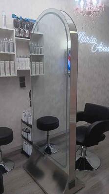Un salón con un espejo en la pared y una silla de peluquería.