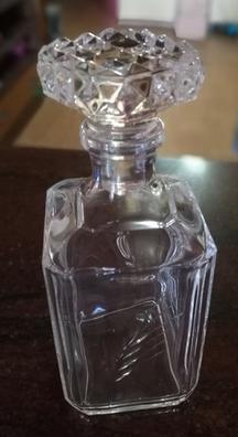 Botella licorera de cristal tallado y cuello de plata.